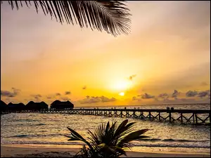 Malediwy na oceanie indyjskim z molo w świetle zachodzącego słońca
