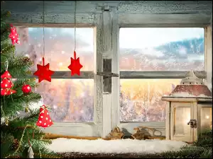 Świątecznie przystrojone okno lampionem i choinką