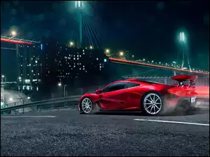Czerwony samochód nocą w oświetlonym mieście