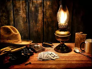 Kompozycja z kapeluszem kowbojskim lampą kostkami i kartami