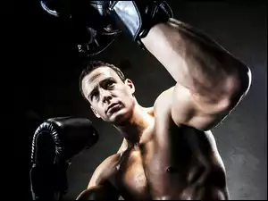 Mężczyzna w bokserskich rękawiczkach na ringu