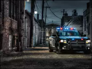 Najszybszy radiowóz policyjny w uliczce pomiędzy kamienicami