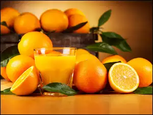 Sok w szklance wśród owoców pomarańczy