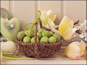 Wielkanocna kompozycja z koszem pisanek i kwiatami
