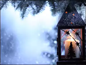 Świąteczny lampion na drzewie na tle śniegu