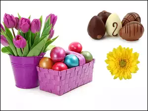 Kompozycja wielkanocna bukietu tulipanów z pisankami w koszyczku i czekoladowymi jajkami