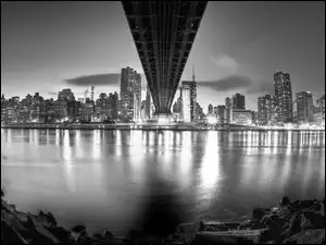 Czarno-białe zdjęcie oświetlonego Nowego Jorku nad rzeką
