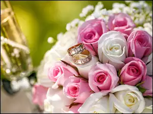 Obrączki położone na bukiecie różowo-białych róż