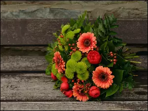 Bukiet kwiatów położony na deskach