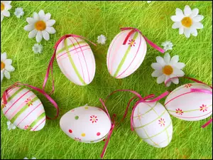 Wielkanocne pisanki ze wstążeczkami na trawie