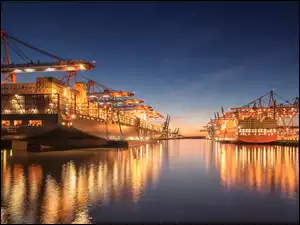 Oświetlony port w Hamburgu ze statkami i dźwigami