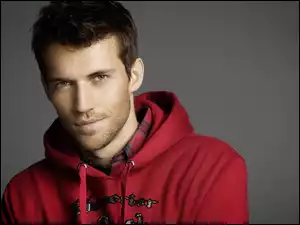 Andrew Cooper-angielski model i aktor w czerwonej bluzie