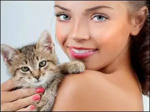 Kobieta z makijażem i małym kotkiem na ramieniu
