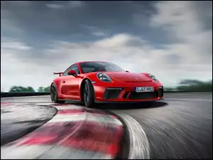 Czerwony samochód Porsche 911 GT3 na zakręcie