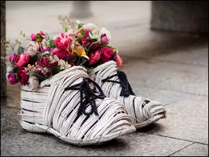 Dekoracja z bukietu kwiatów w słomkowych butach