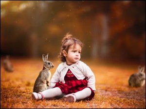 dziewczynka bawi się z króliczkami