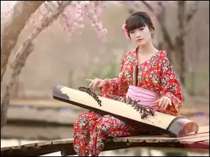 Azjatka w kimonie z japońskim instrumentem Koto