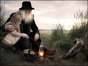 dziewczynka w objęciach dziadka z zapaloną lampką