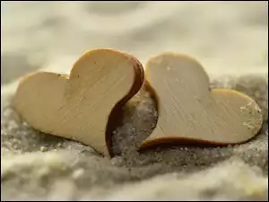 Dwa serca drewniane na piasku