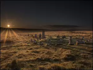 Promienie słońca padają na kamienie w angielskim Parku Narodowym Dartmoor