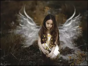 Dziewczynka anioł kucająca na polu