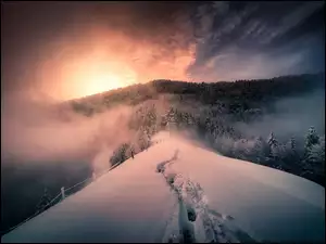 Zachód słońca nad zimowymi leśnymi górami