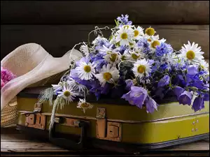 Bukiet kwiatów położony na walizce