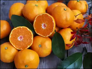 Pomarańcze i liście leżą na deskach
