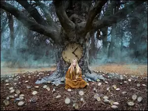 Blondynka z drzewem zegarem w lesie