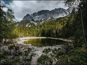 Jezioro pośrodku lasu z widokiem na góry