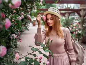 Modelka w parku z krzewem róż