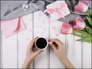Filiżanka kawy z tulipanami i prezentem