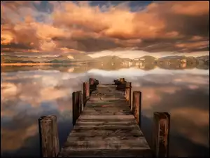 niebo z purpurowymi chmurami nad pomostem w jeziorze