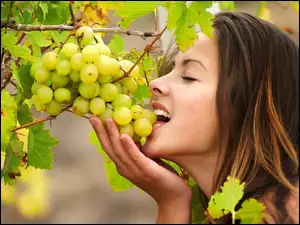 Kobieta próbująca zielone winogrona