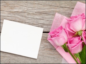 Bukiet róż na deskach obok kartki