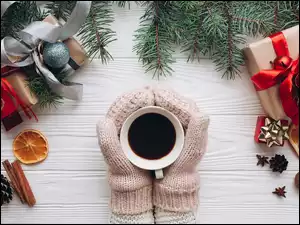 Kawa w dłoniach z rękawiczkami i ozdobami