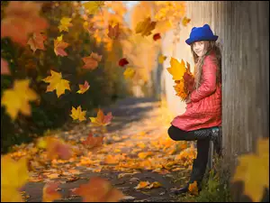 Dziewczynka w śród opadających Jesiennych liści