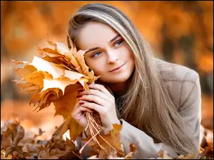 Piękna kobieta z jesiennymi liśćmi