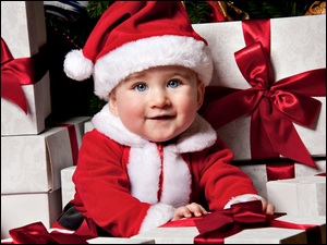 Dziecko w stroju Mikołaja z prezentami
