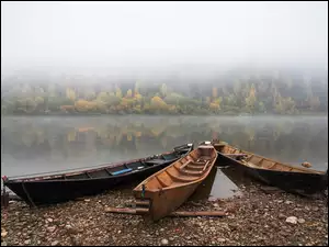 Trzy łodzie na zamglonym jeziorze