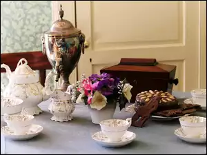 Zastawa porcelanowa z ciastem i kwiatami na stole