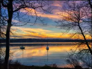 Jachty na jeziorze w blasku zachodzącego słońca