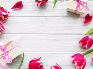 Rozrzucone tulipany i prezenty na deskach