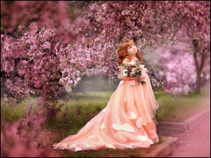 Dziewczynka w strojnej sukience w ogrodzie z kwiatami