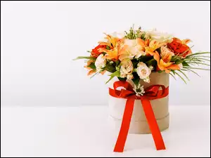 Bukiet kwiatów w pudełku przewiązanym wstążką