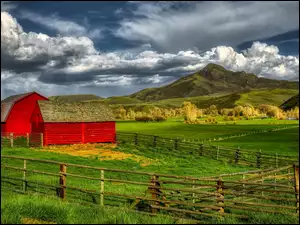 Czerwone stodoły na polu w górach