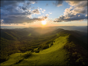 Zielone wzgórza o wschodzie słońca