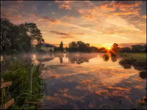 Dom nad jeziorem w Anglii w promieniach zachodzącego słońca
