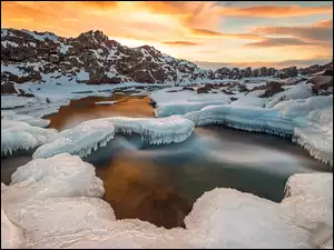 Ośnieżona i oblodzona rzeka w Parku Narodowym Pingvellir na Islandii