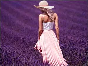 dziewczyna w zwiewnej sukni i kapeluszu na polu lawendowym